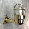 A reclaimed retro industrial solid brass 90 degree outdoor wall light with protective cage.