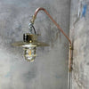 A vintage industrial style copper swing arm wall light with brass explosion proof pendant light.