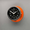 A non-ticking orange nautical style wall clock with black face, reclaimed and restored by AC.GMT.Co.