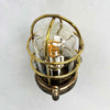 This robust industrial cage wall light manufactured C1995, comprises a cast steel main body, a tempered glass dome with a protective brass and bronze cage.