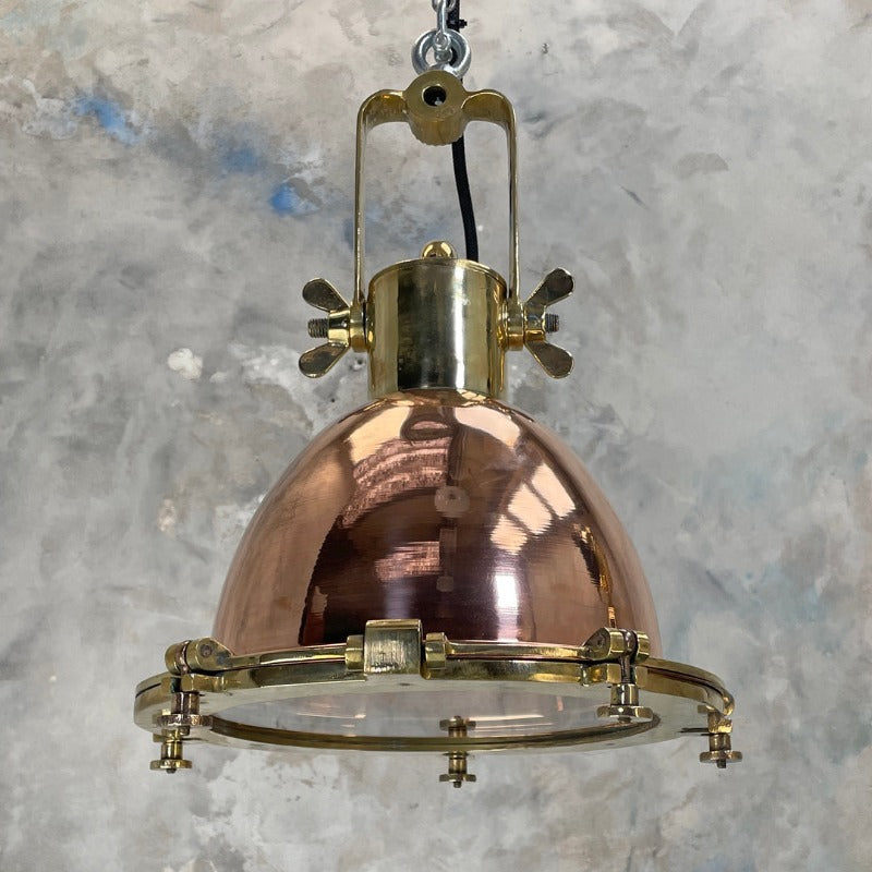 A copper and brass industrial style ceiling light. Perfect industrial lighting for hanging over a kitchen island or to fill a tall ceiling. The highly polished copper and brass have a  wonderful rich red tone to add warmth and metallic texture to your interior