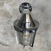 A vintage cast aluminum wall light with prismatic glass shade and industrial style protective cage by Appleton