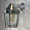 A vintage cast aluminum wall light with prismatic glass shade and industrial style protective cage by Appleton
