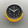 A silent yellow circular wall clock with black face, reclaimed and restored by AC.GMT.Co.