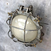 A vintage industrial circular frosted iron wall bulkhead light.