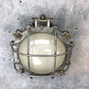 A vintage industrial circular frosted iron wall bulkhead light.