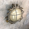 A vintage industrial circular frosted iron wall bulkhead light.