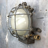 A vintage industrial circular frosted iron wall bulkhead light.