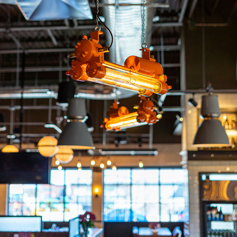 Vintage industrial orange LED strip light. Retro Edison Tube Strip Light refurbished by British lighting restoration specialists Loomlight. Ceiling Mounted in The Beertown, Sports Bar in USA