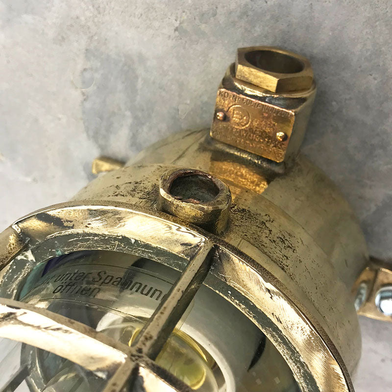 Vintage industrial brass explosion proof light with isolator switch by Wiska. Suitable for outdoor use. Features a cast brass protective cage. Original industrial lighting. 