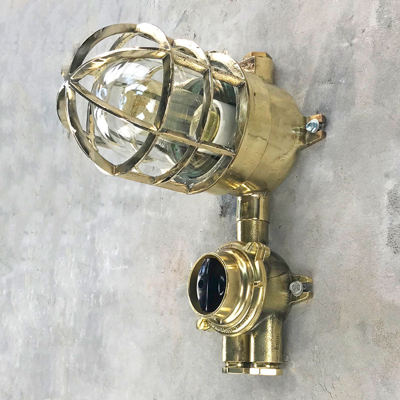 Vintage industrial brass explosion proof light with isolator switch by Wiska. Suitable for outdoor use. Features a cast brass protective cage. Original industrial lighting. 