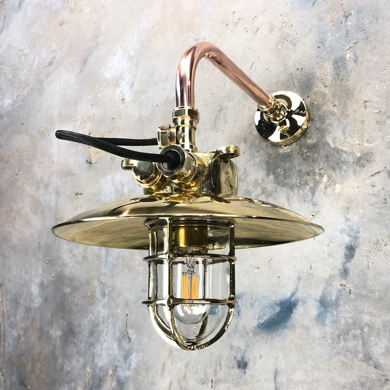 Vintage industrial style cantilever wall light with brass explosion proof cage light suspended to a copper pipe wall arm and brass wall fixing plate. Compatible with LED light bulbs. Restored & rewired ready to install.