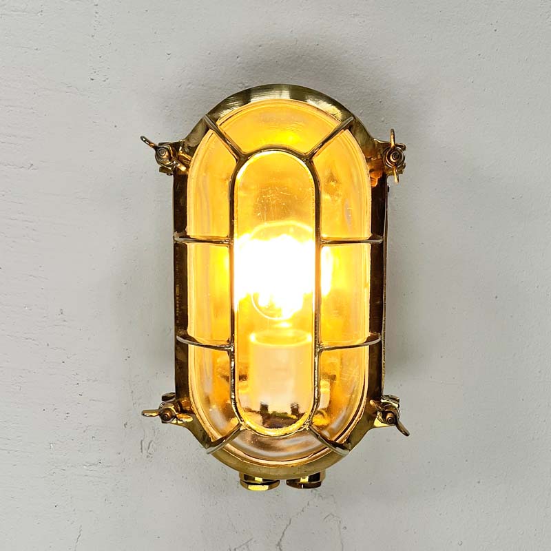 a vintage brass bunker light which is an industrial wall light professionally restored for modern interiors. Fitted with LED light bulbs this cast brass wall light is ideal for creating industrial style interiors.