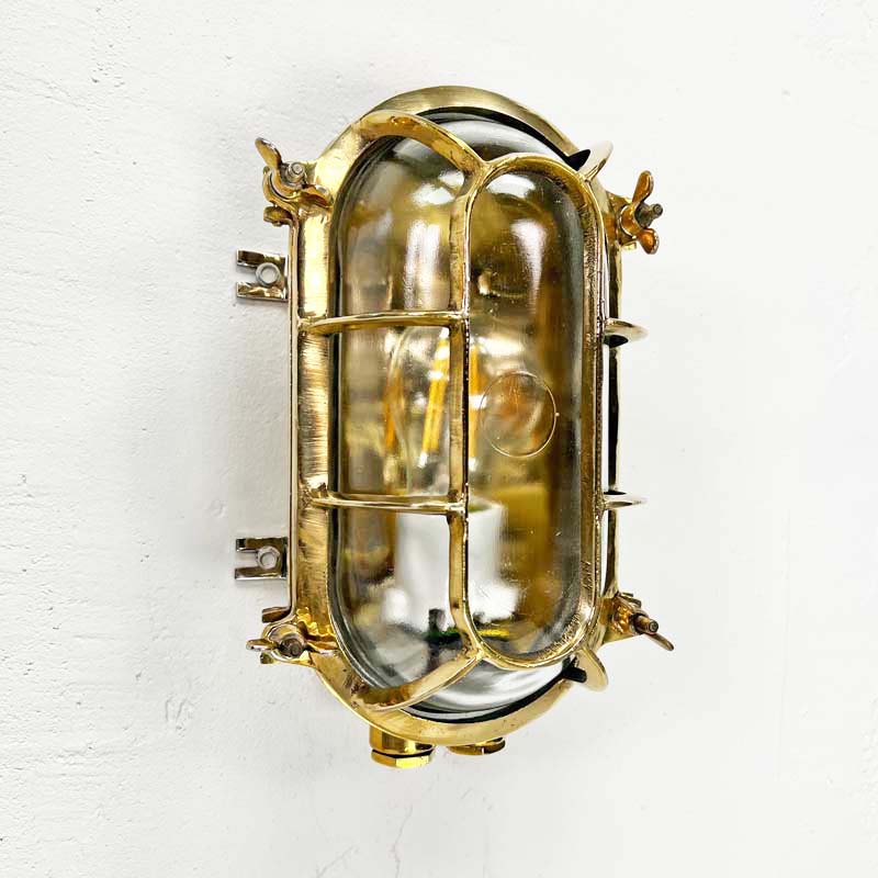 a vintage brass bunker light which is an industrial wall light professionally restored for modern interiors. Fitted with LED light bulbs this cast brass wall light is ideal for creating industrial style interiors.