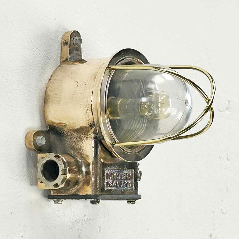 The Kokosha brass wall light is the epitome of industrial design. This vintage industrial light fixture is refurbished in-house and compatible with LED light bulbs. Ideal for modern interiors looking to inject vintage industrial edge.