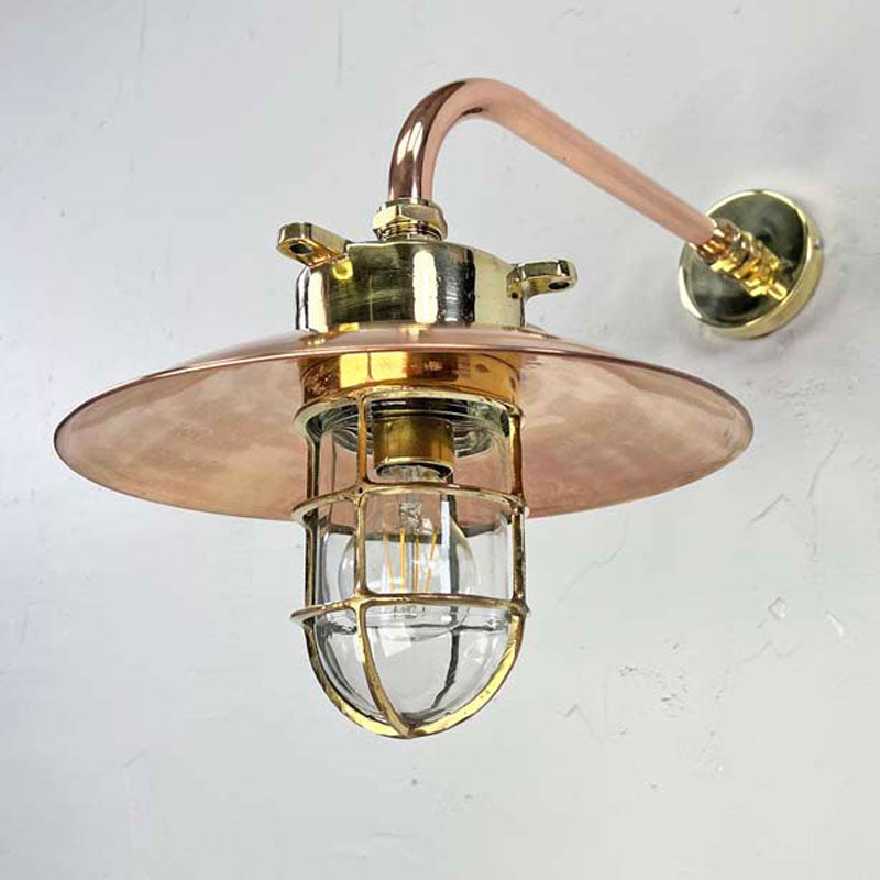 The copper cage wall light is a reclaimed original industrial explosion proof brass lamp. Full of industrial style with a protective brass cage, copper shade and copper wall arm this wall lamp is beautifully restored for modern interiors