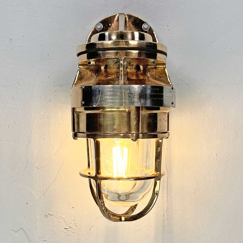 A robust bronze industrial outdoor light reclaimed from decommissioned cargo ships. This is a vintage industrial wall light made by the American company Pauluhn Electric Manufacturing.&nbsp;We have professionally restored this wall light so they are ready to install outdoors and use with LED light bulbs. Or use indoors for authentic industrial look &amp; feel.