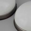 Two round white ceiling lights on a gray background
