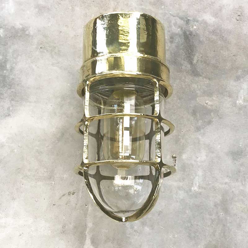 Shop our vintage brass ships light. A 90 degree lamp with cast brass cage and tempered glass cover.  Industrial lighting reclaimed and restored for modern interiors. This wall lamp can be used outdoors. It is compatible with an LED light bulb. Manufactured by Daeyang a Korean company who made fixtures for industrial purposes. 