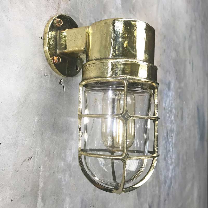 Shop our vintage brass ships light. A 90 degree lamp with cast brass cage and tempered glass cover. Industrial lighting reclaimed and restored for modern interiors. This wall lamp can be used outdoors. It is compatible with an LED light bulb. Manufactured by Daeyang a Korean company who made fixtures for industrial purposes.