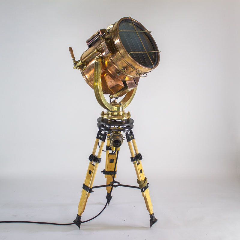 a large vintage brass search light tripod made by Shonan kosakusho of Japan. A WW2 signalling lamp used on ships, Loomlight have full restored the search light and paired it with a wooden tripod which includes a switch. A fully functioning vintage industrial floor lamp