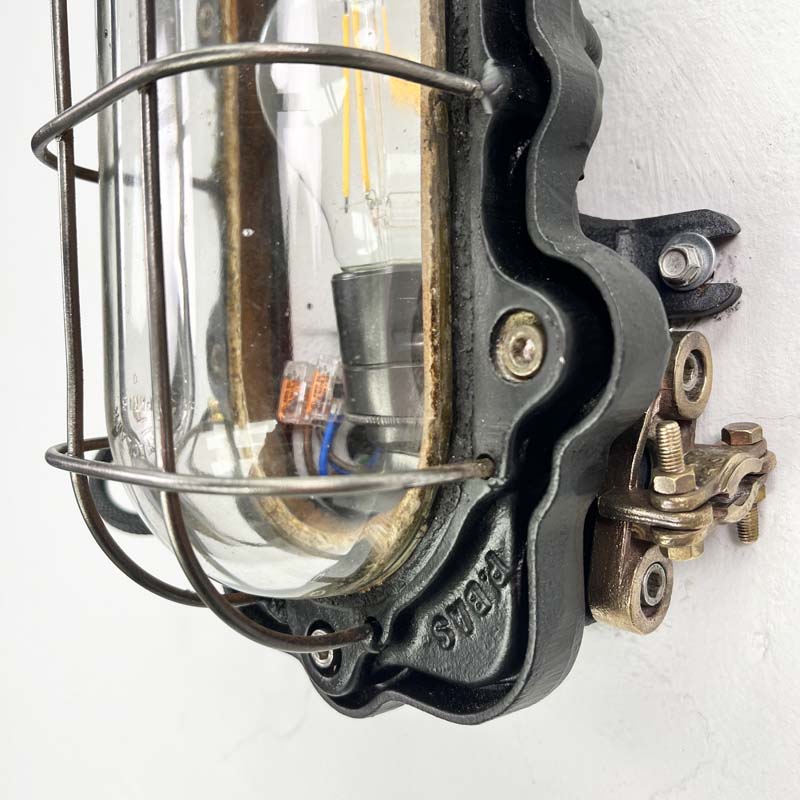 Vintage industrial indoor bulkhead light by Perfeclair, made in cast steel painted black with a protective cage over the lampholder. Fully rewired and restored ready for modern interiors. 