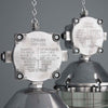 Two industrial-style metal pendant lights with visible branding on a gray background