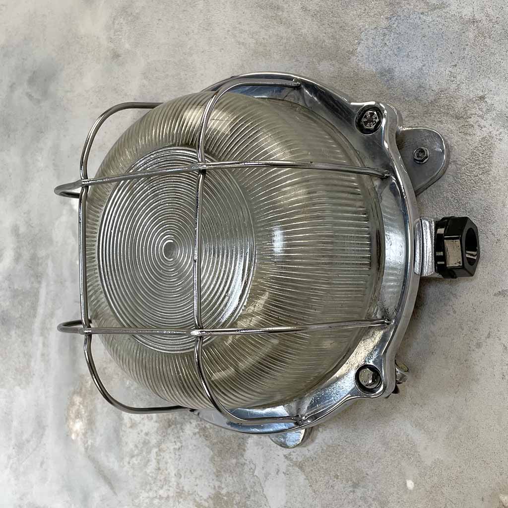 Vintage industrial circular aluminium bulkhead wall light with prismatic glass and protective cage for outdoor use and indoor use