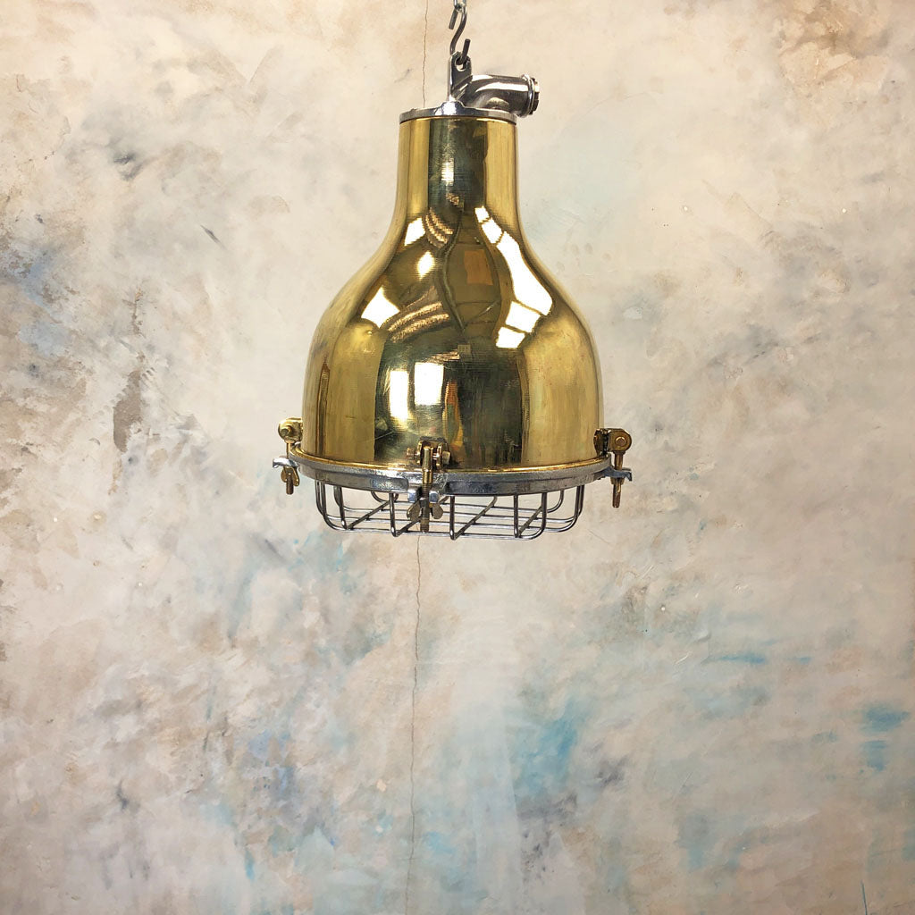 A vintage brass dome ceiling pendant light fixture with an aluminium industrial style cage. 