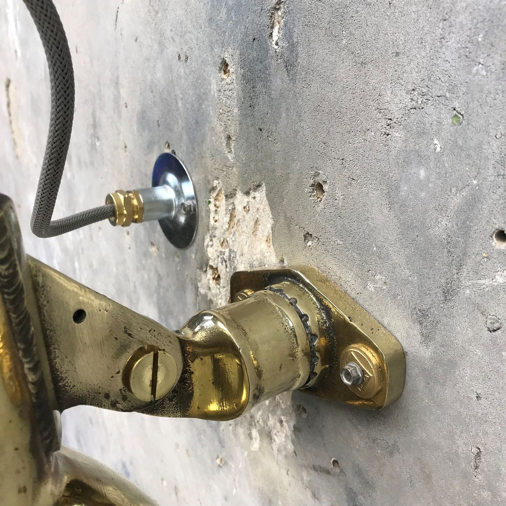 A reclaimed retro industrial cast brass directional outdoor wall washer light.