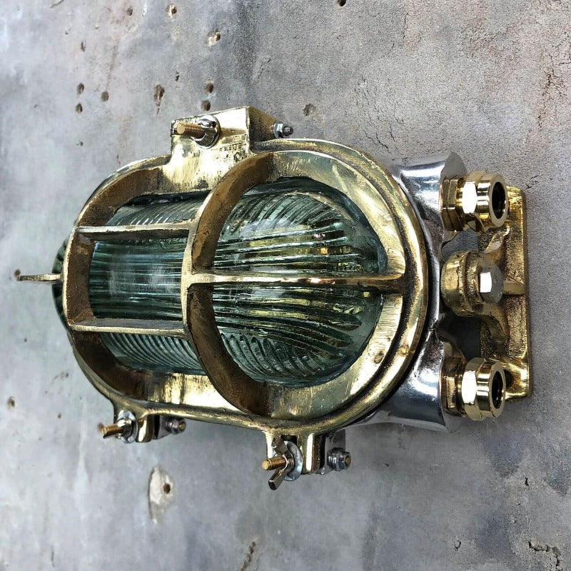 A vintage industrial brass and aluminium tilting wall bulkhead wall light with prismatic glass.