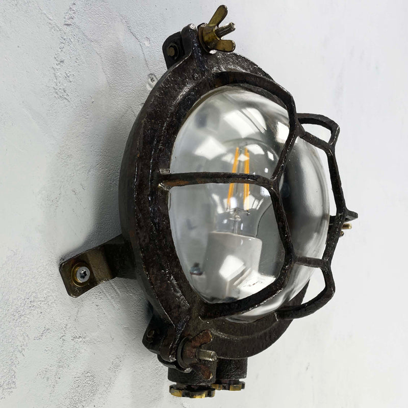 Shop our black round bulkhead made from black cast iron with a glass dome cover which has a cage protector. This vintage industrial wall light is an ideal feature light for ultimate industrial chic