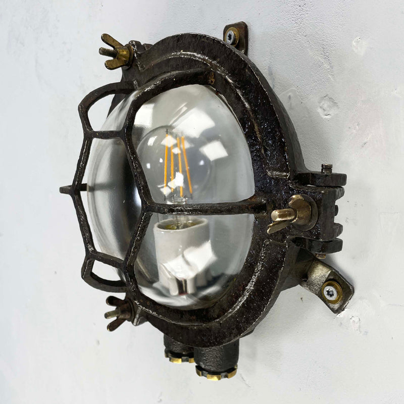 Shop our black round bulkhead made from black cast iron with a glass dome cover which has a cage protector. This vintage industrial wall light is an ideal feature light for ultimate industrial chic