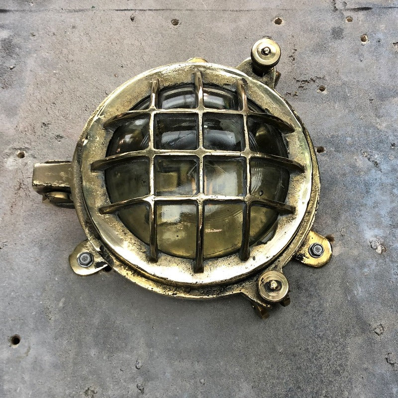 A small vintage industrial cast bass and glass circular bulkhead wall light