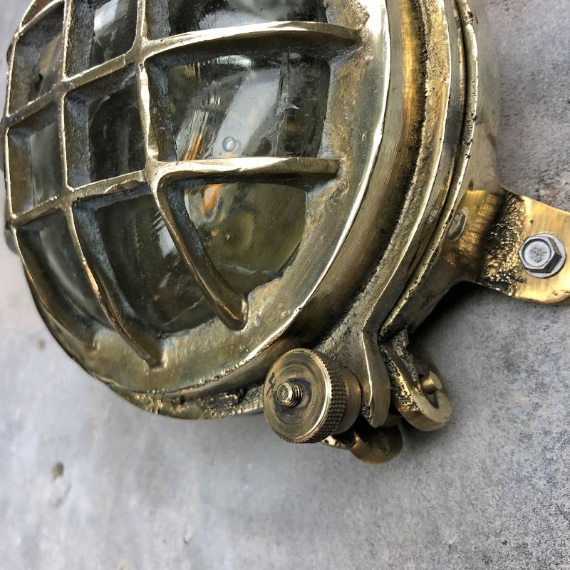 A small vintage industrial cast bass and glass circular bulkhead wall light