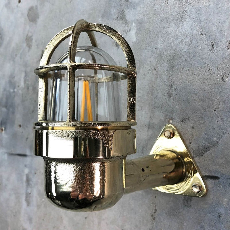 A reclaimed retro industrial solid brass 90 degree outdoor wall light with protective cage. 