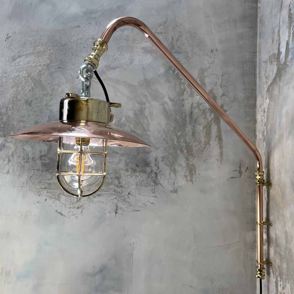 A vintage industrial style copper swing arm wall light with brass explosion proof pendant light.