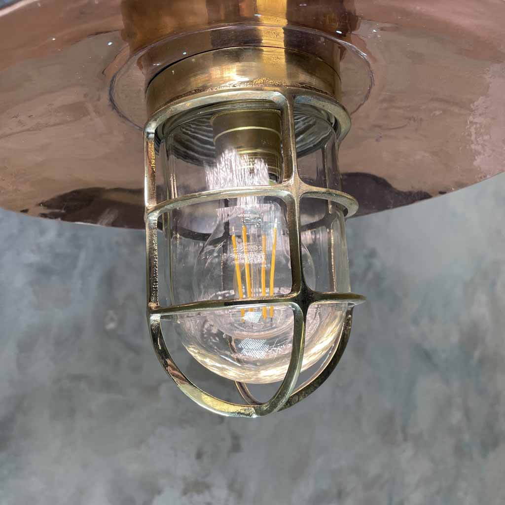 A vintage industrial style copper swing arm wall light with brass explosion proof pendant light.