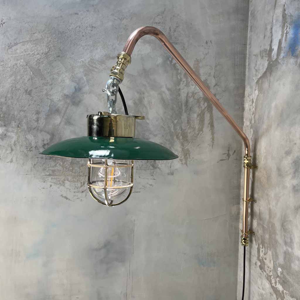 A vintage industrial style copper swing arm wall light with brass explosion proof pendant light with a green enamel shade.