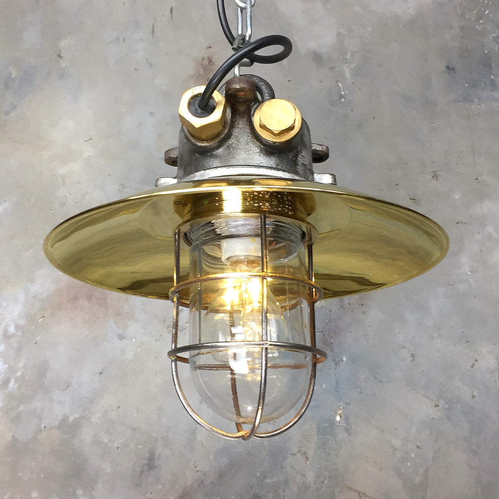 A reclaimed industrial explosion proof iron and brass cage light ceiling pendant. 