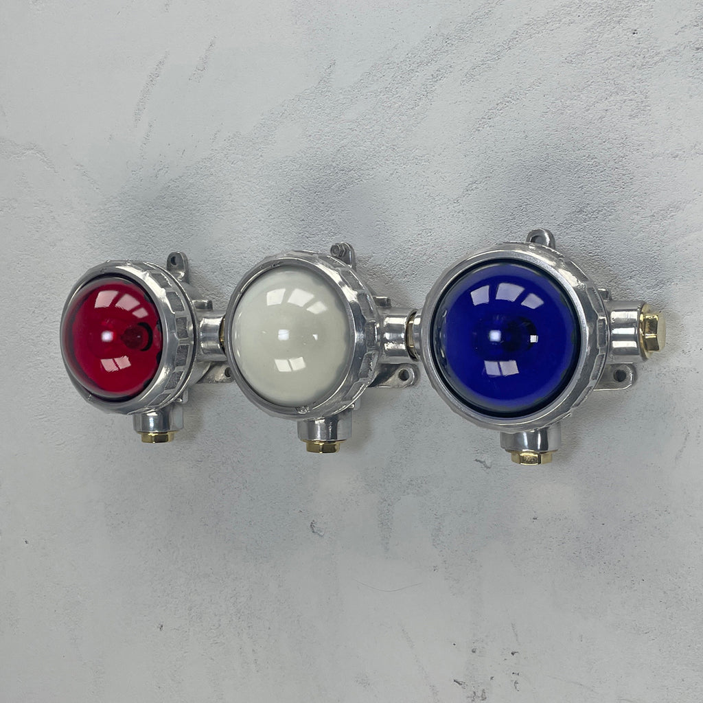 An original industrial cast aluminium, brass and red, white & blue glass micro spot trio wall light fixture. 