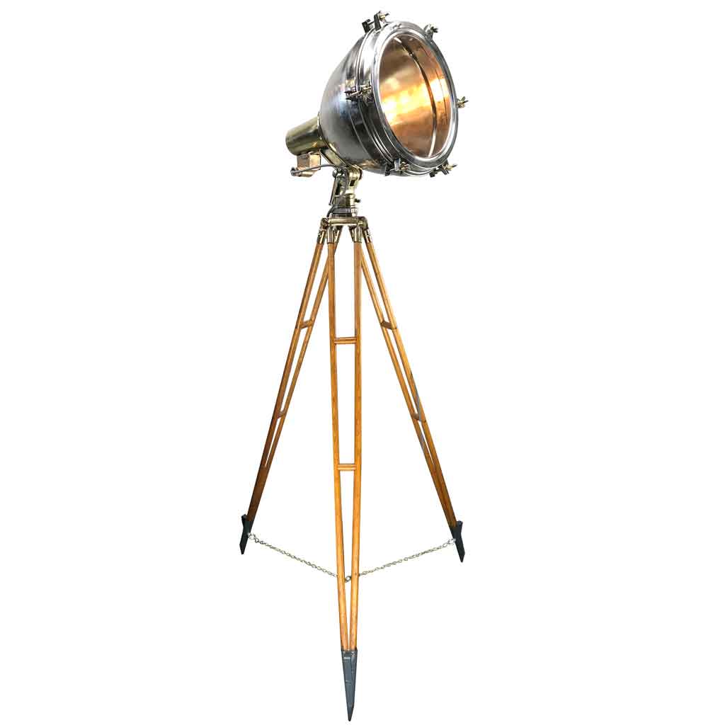 A vintage industrial floor lamp in stainless steel and brass. The steel Searchlight is paired with a timber and bronze tripod to create a unique bespoke floor lamp.