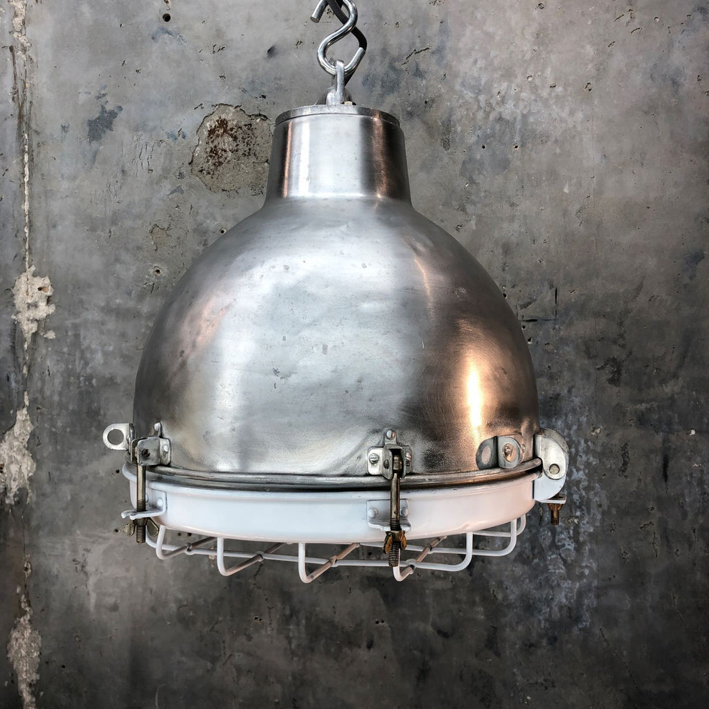A vintage industrial polished aluminium dome ceiling light with white painted protective cage.