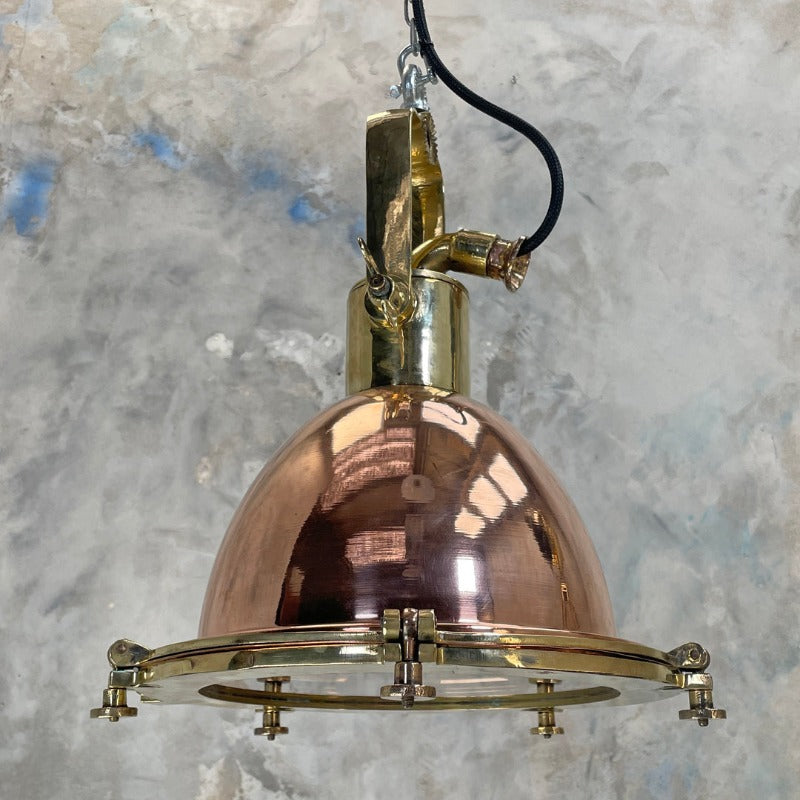 A copper and brass industrial style ceiling light. Perfect industrial lighting for hanging over a kitchen island or to fill a tall ceiling. The highly polished copper and brass have a  wonderful rich red tone to add warmth and metallic texture to your interior