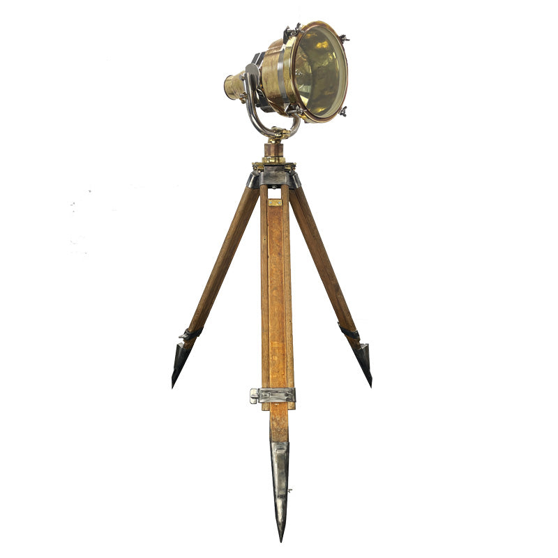 A stunning vintage Japanese brass search light paired with a wooden British antique surveyors tripod, to create a completely unique tripod floor lamp.