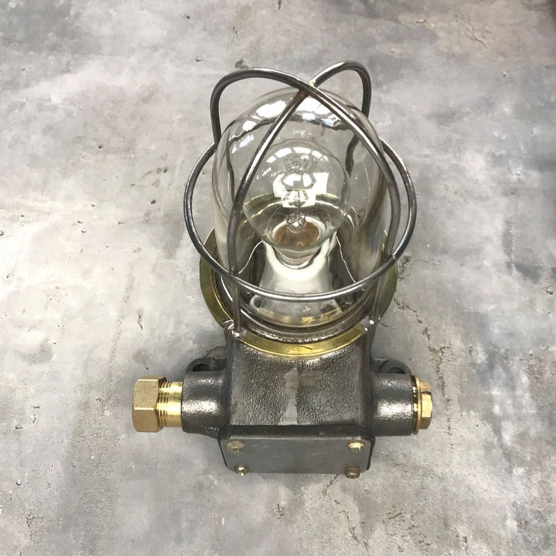 A reclaimed vintage industrial explosion proof outdoor iron wall light with cage, made c1970.