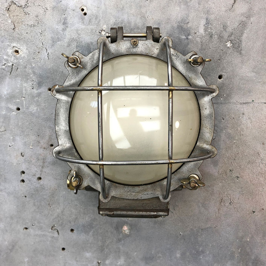 A vintage industrial circular frosted iron wall bulkhead light. 