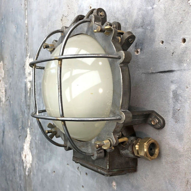 A vintage industrial circular frosted iron wall bulkhead light. 