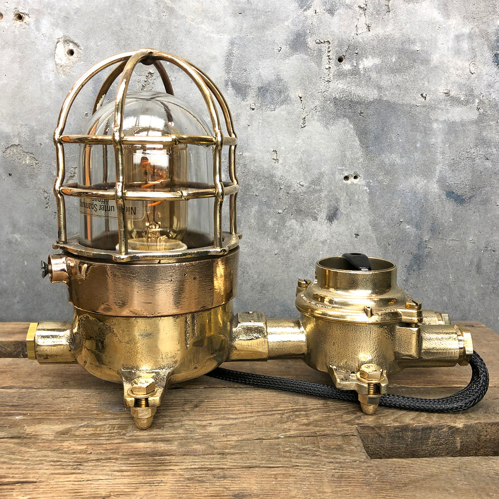 A vintage industrial cast bronze and brass explosion proof table lamp with an isolator switch