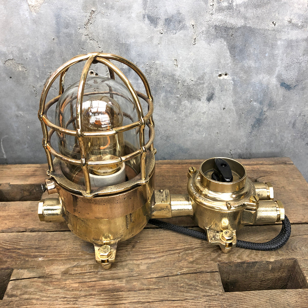 A vintage industrial cast bronze and brass explosion proof table lamp with an isolator switch